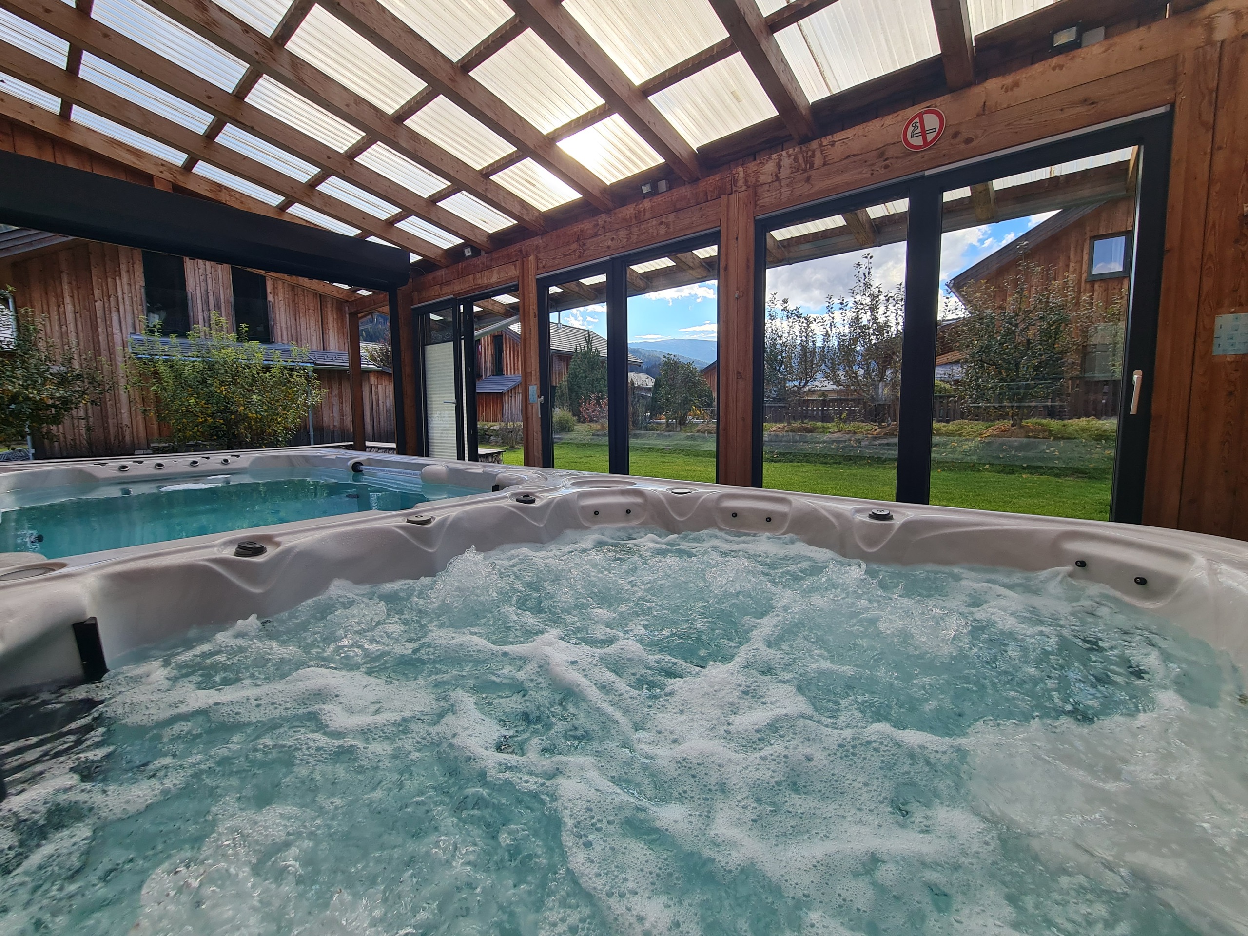 Pool und Whirlpool im überdachten Wellnessbereich